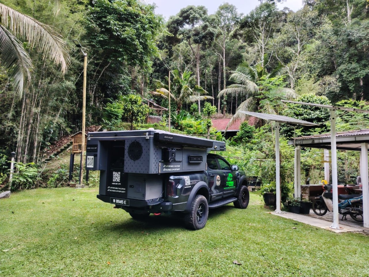 WOW camper at a lush green campsite